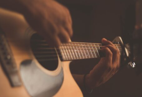 person playing on a guitar