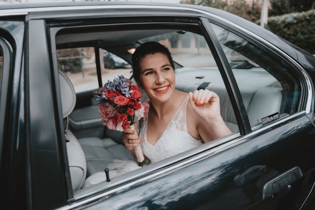 person in wedding car with flowers