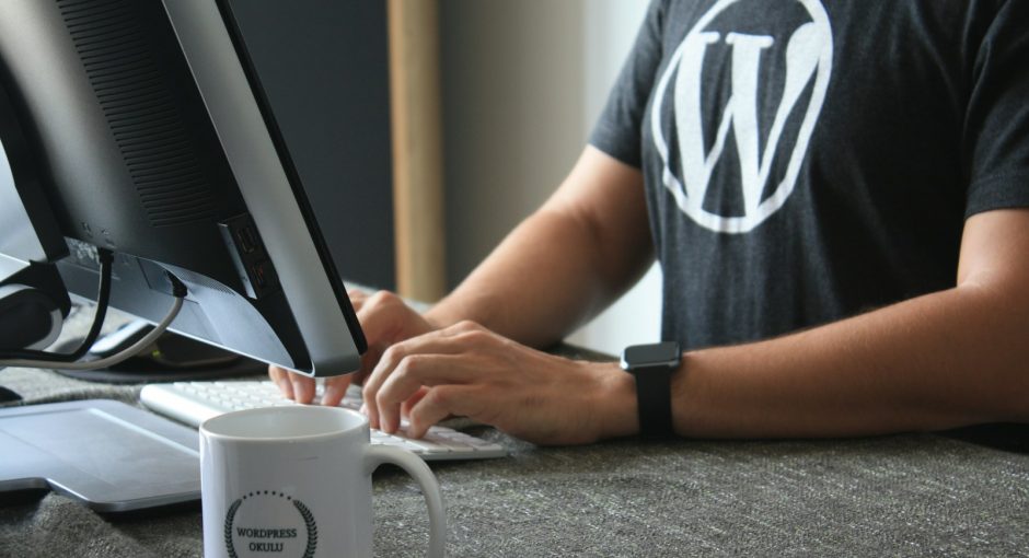 person in black and white t-shirt using computer