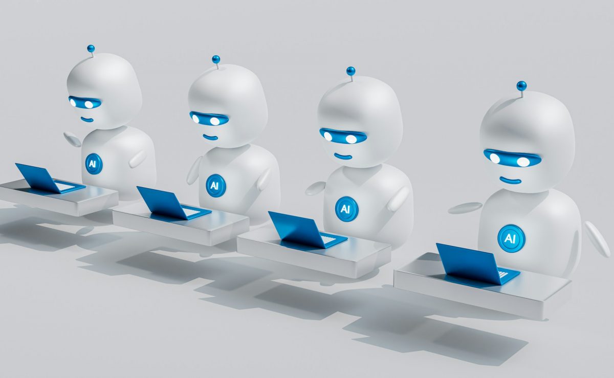 a-group-of-white-robots-sitting-on-top-of-laptops