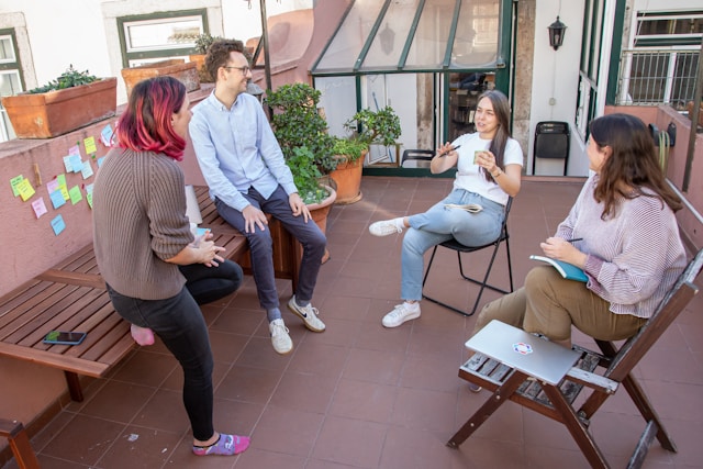 a-group-of-people-sitting-around-a-wooden-bench